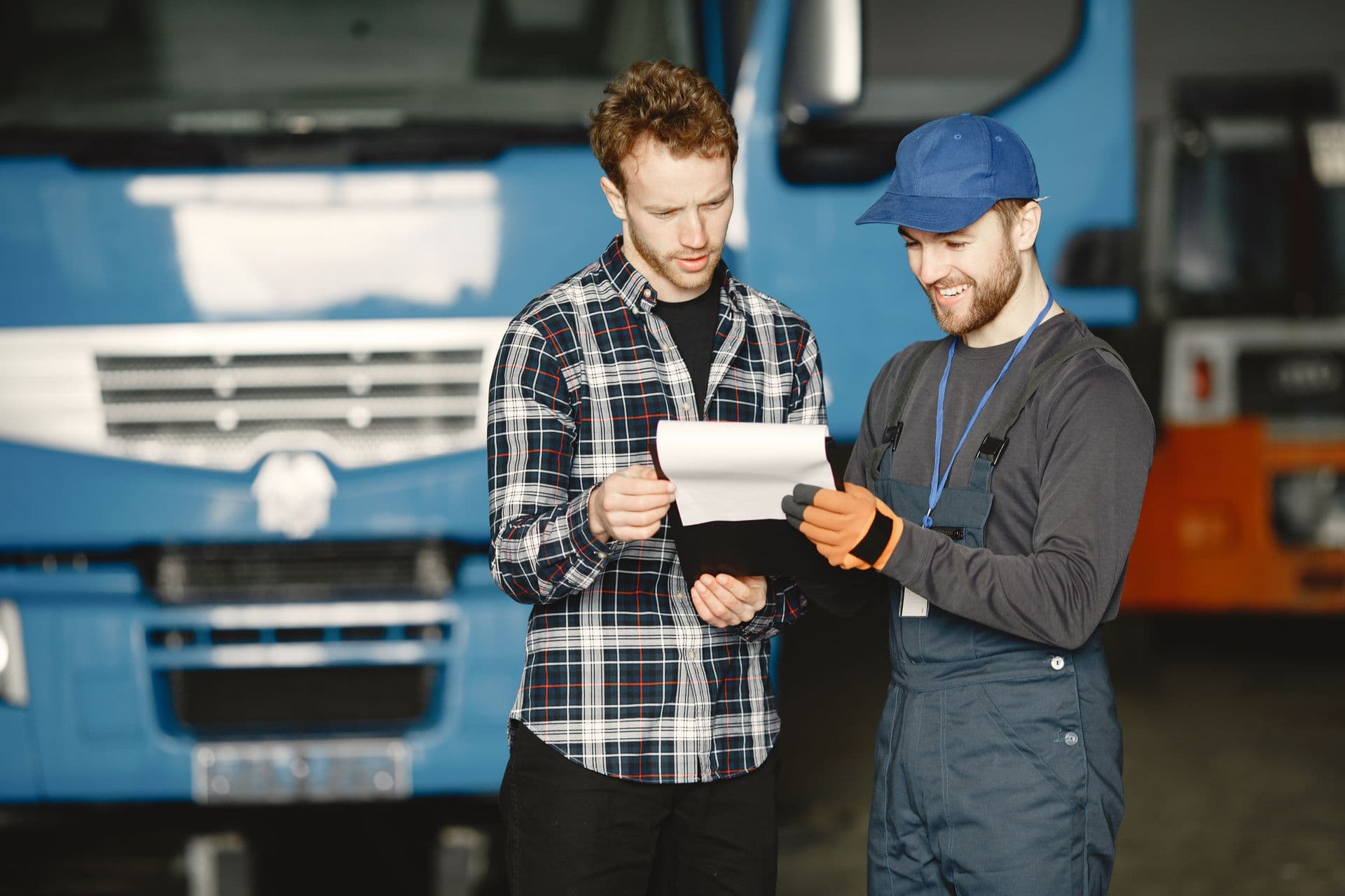 Instructor and trainee reviewing paperwork beside a truck